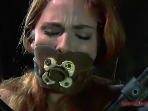 Redhead slave with a blindfold moans during a BDSM game