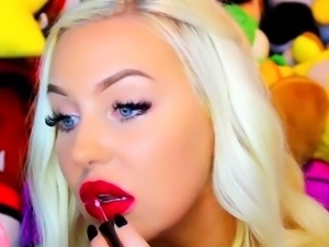 Beautiful blonde model tries on different lipstick on webcam